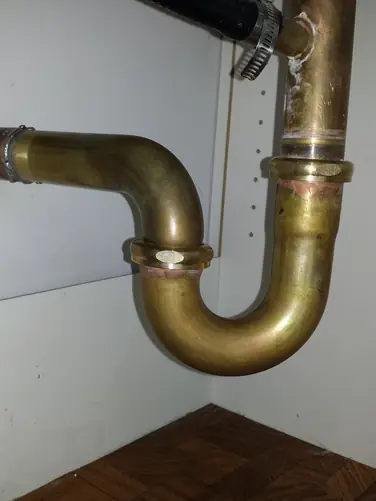 New brass P-trap installed clean — Woodbridge